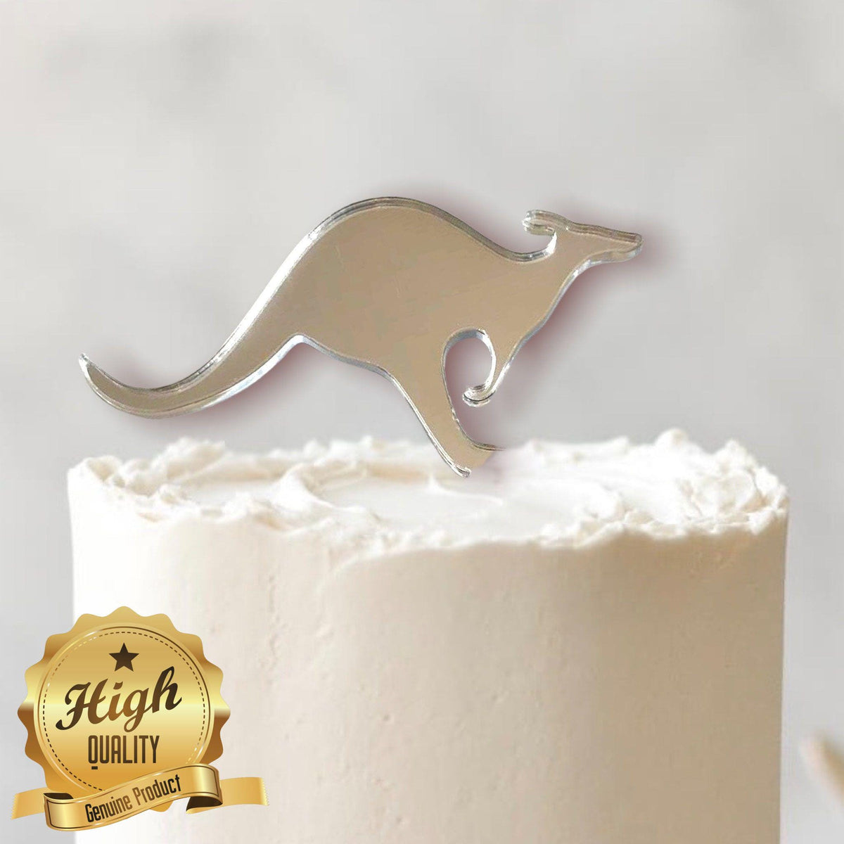 A silver mirror-finish acrylic kangaroo-shaped cake topper displayed on a white frosted cake.