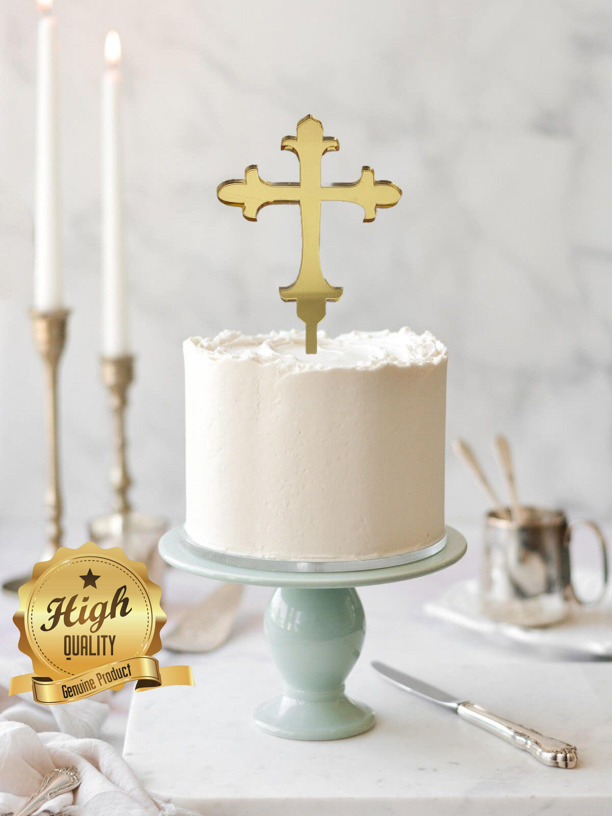 Shiny gold laser-cut cross cake topper on a simple white frosted cake atop a light green cake stand.
