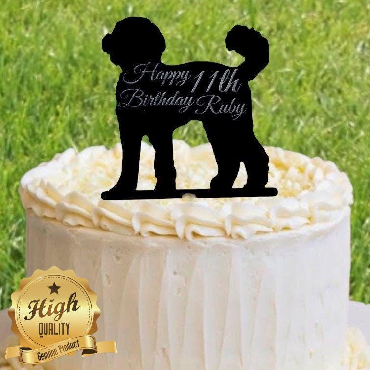 Black silhouette Cockapoo cake topper on a frosted cake, engraved with "Happy 11th Birthday Ruby."