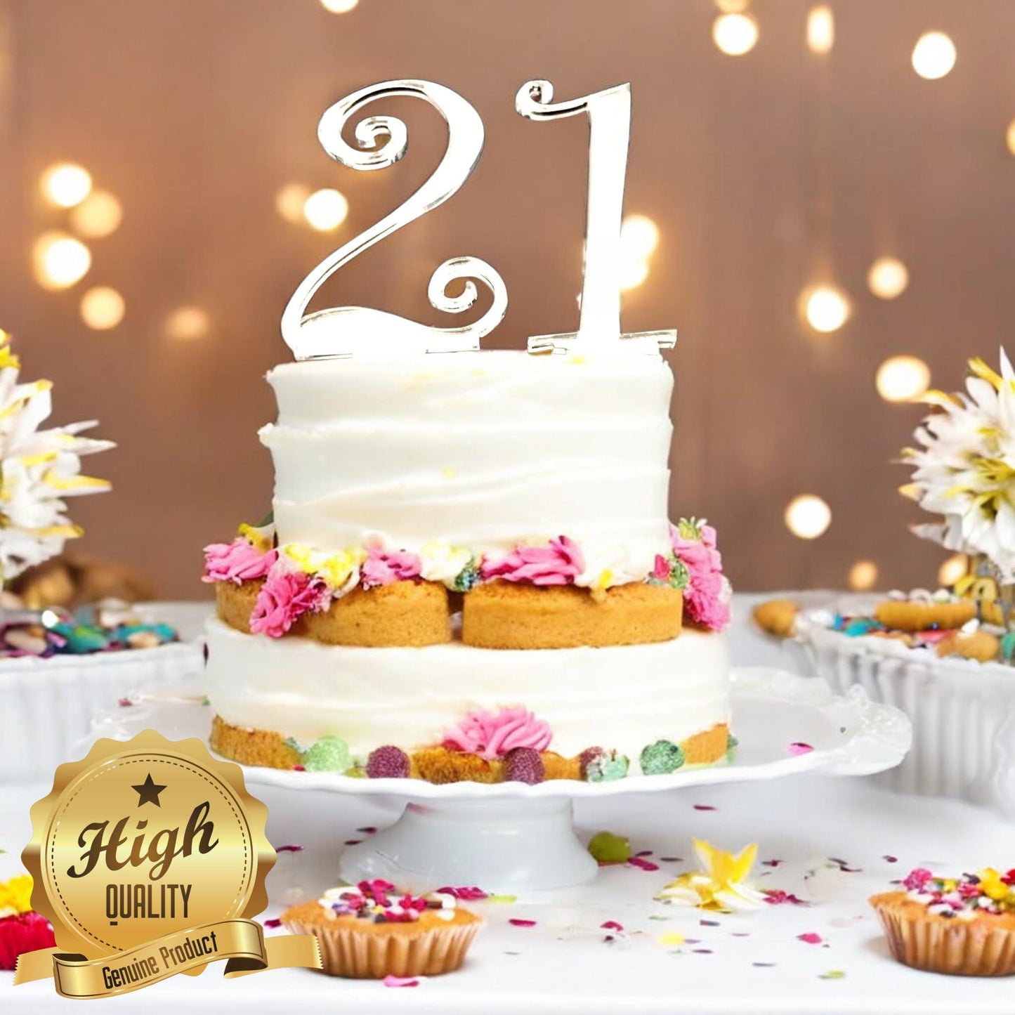 A shiny, silver-mirrored acrylic number "21" cake topper in an elegant cursive font, placed atop a two-tier cake.