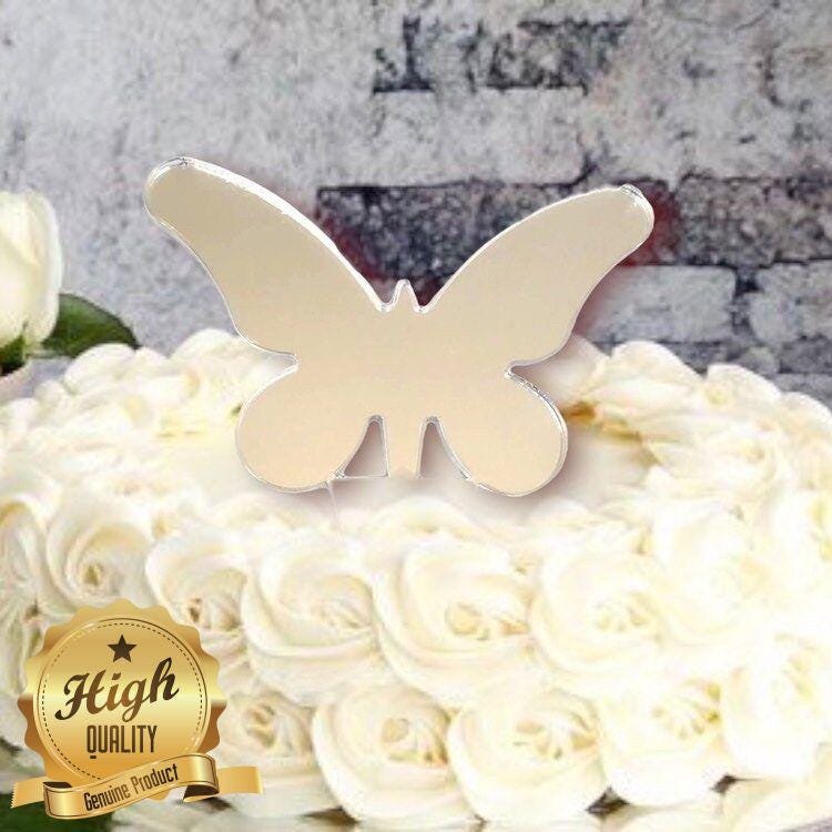 Reflective, long-winged butterfly cake topper by SuperCoolCreations centered on a white frosted cake.