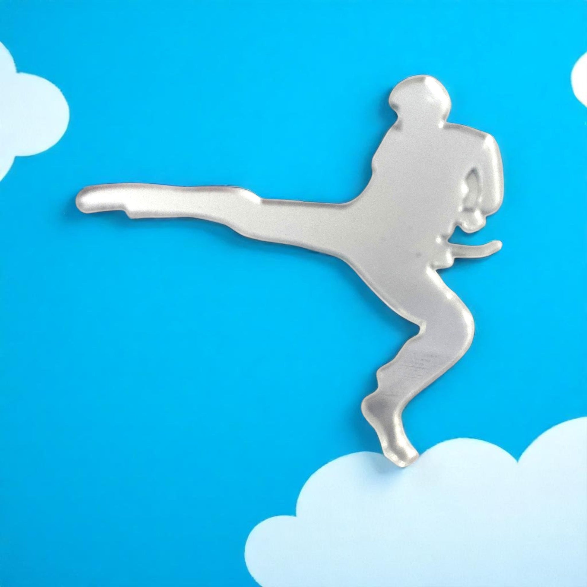 Silver martial arts man-shaped mirror against a blue sky background with white clouds.