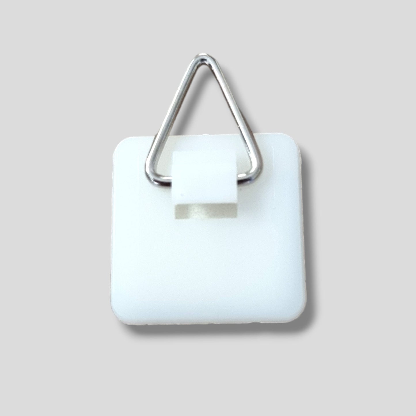 Silver triangle D-ring hanger attached to a square white plastic base.