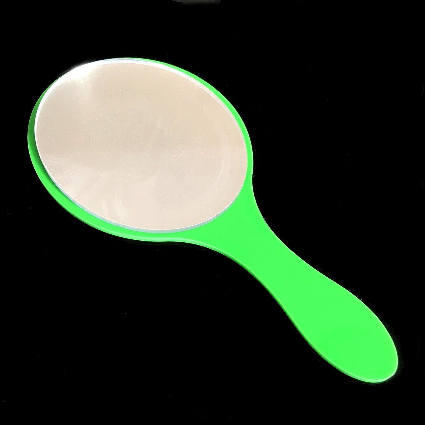 An oval hand-held mirror with a bright green gloss handle on a black background.