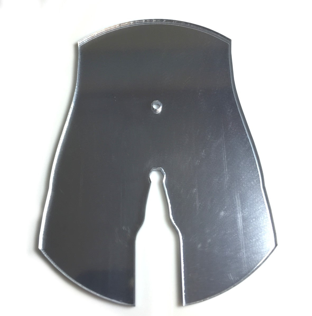 A reflective silver mirror cut into a bottle shape with a central hole.