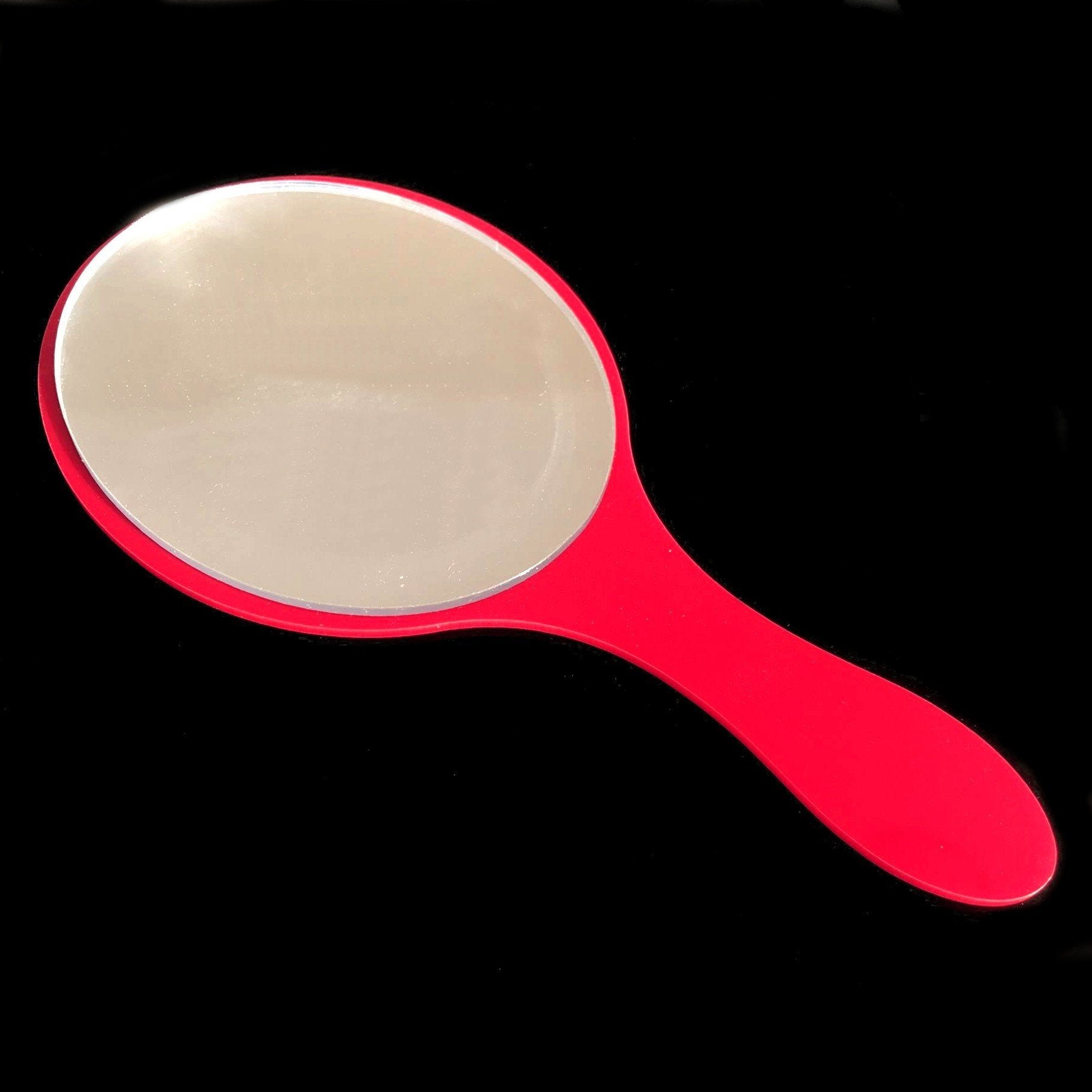An oval hand-held mirror featuring a glossy red frame and handle against a black background.