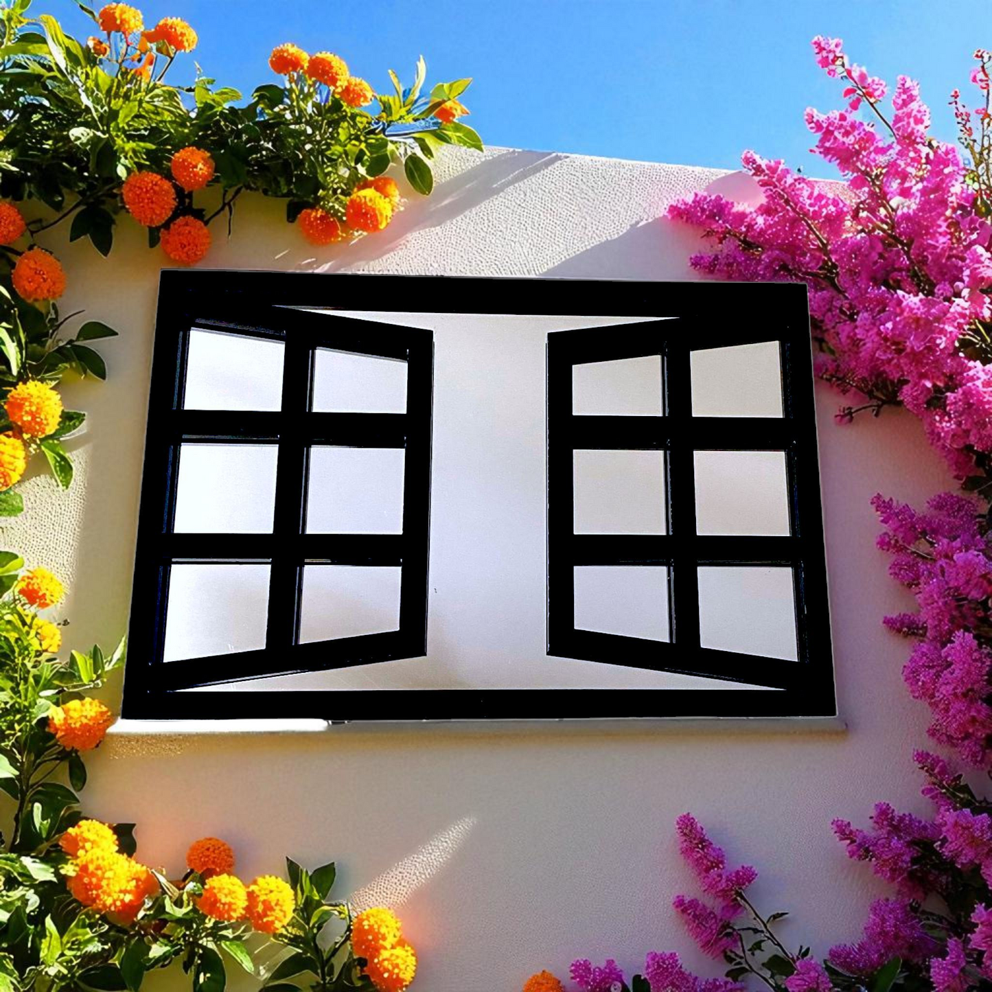 Rectangular black-framed window mirror mounted on a white wall surrounded by orange and pink flowers.