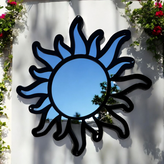 Sun framed garden mirror with a black metal frame and wavy sunray design, mounted on a white wall.