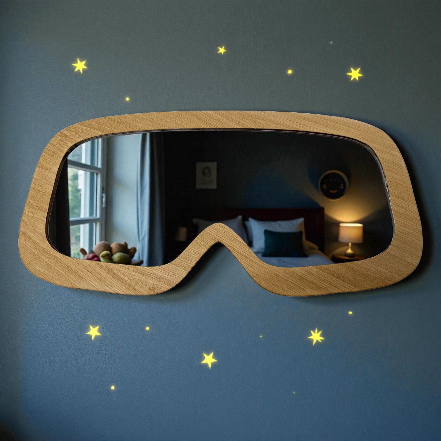 Ski-goggle-shaped wall mirror with a light wood frame, hanging on a blue wall decorated with yellow star stickers.
