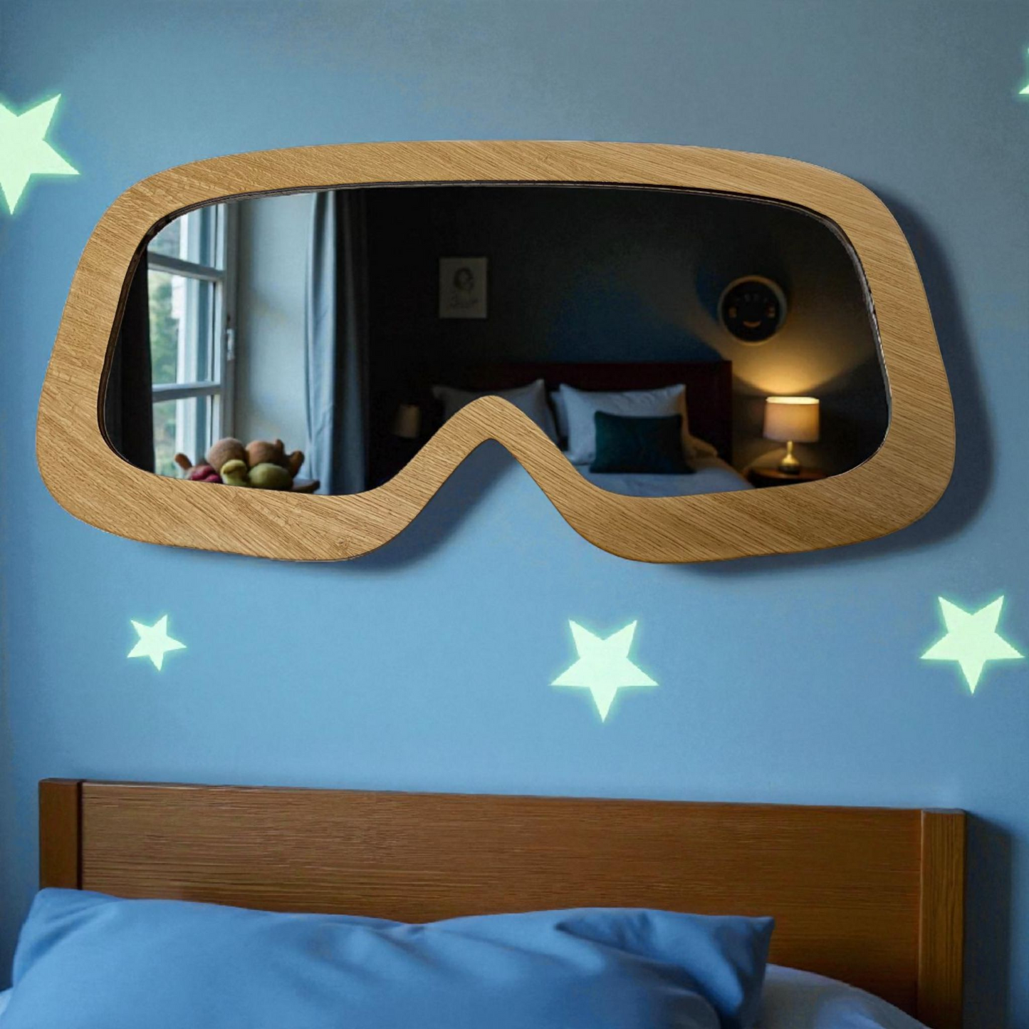Ski goggle-shaped wood-framed mirror mounted on a blue bedroom wall with glowing star stickers.
