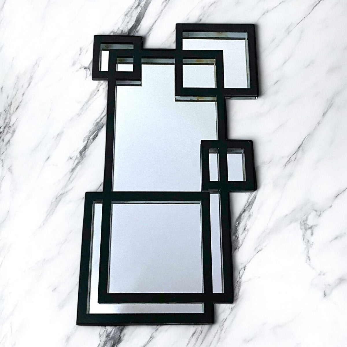 Contemporary black-framed garden mirror composed of overlapping rectangular and square geometric shapes.