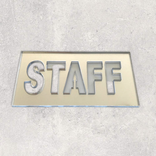 Rectangular reflective acrylic Staff sign with cut-out block letters, placed on a light grey surface.