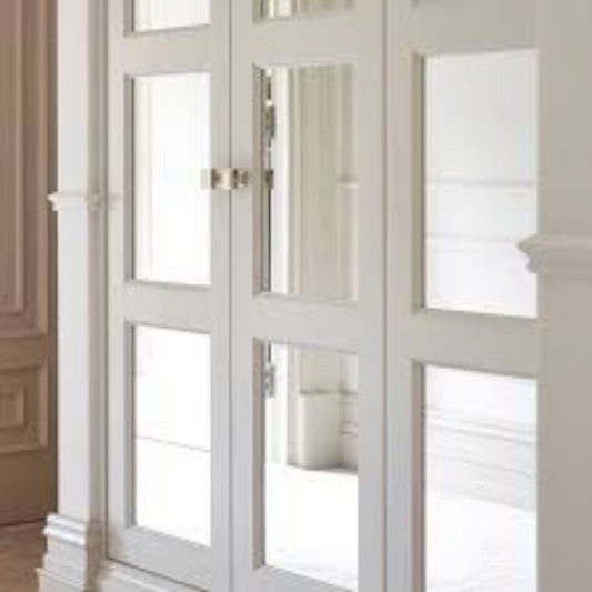 White wardrobe doors fitted with custom rectangular inset mirrors.