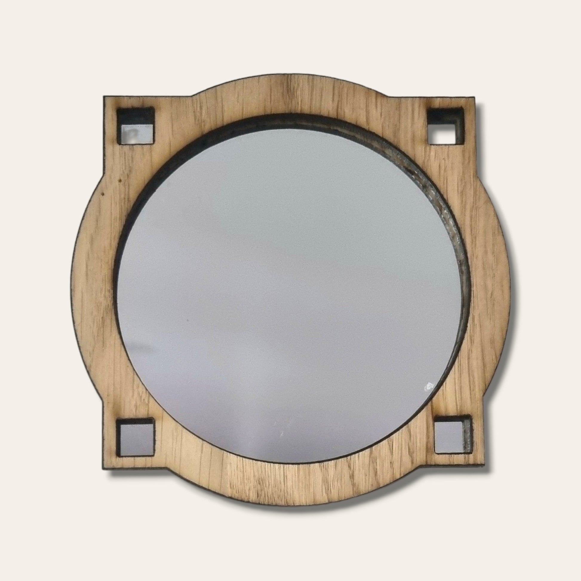 Art Deco style round mirror in a light wood frame with four square corner cutouts.