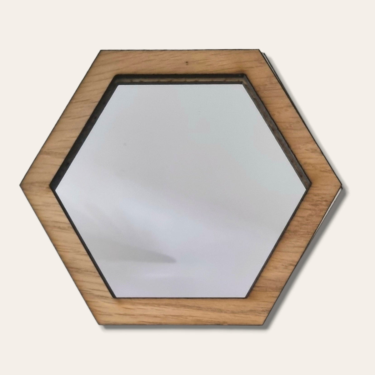 A hexagonal mirror with a light brown natural wood frame.