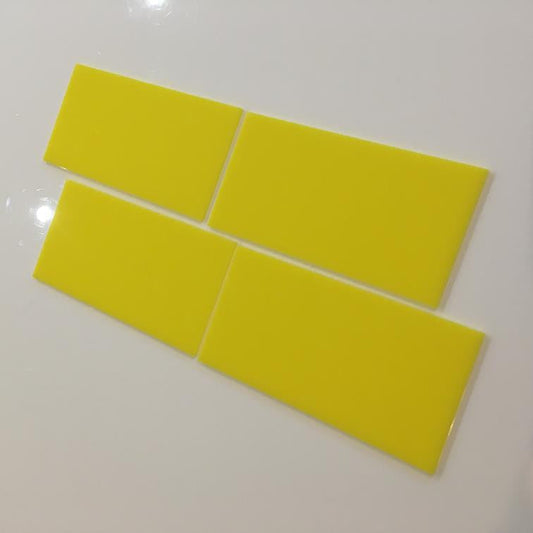 Four bright yellow rectangular tiles arranged in a staggered pattern on a white surface.